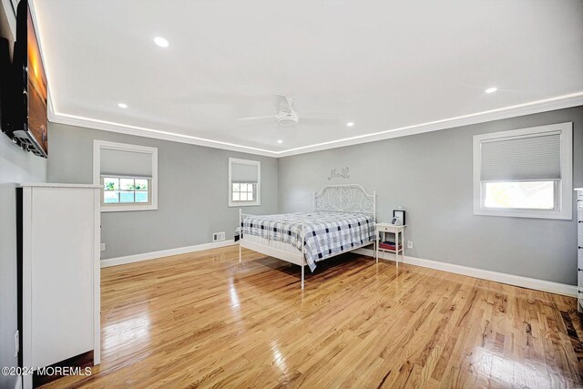 bedroom featuring light hardwood / wood-style floors, ornamental molding, and ceiling fan