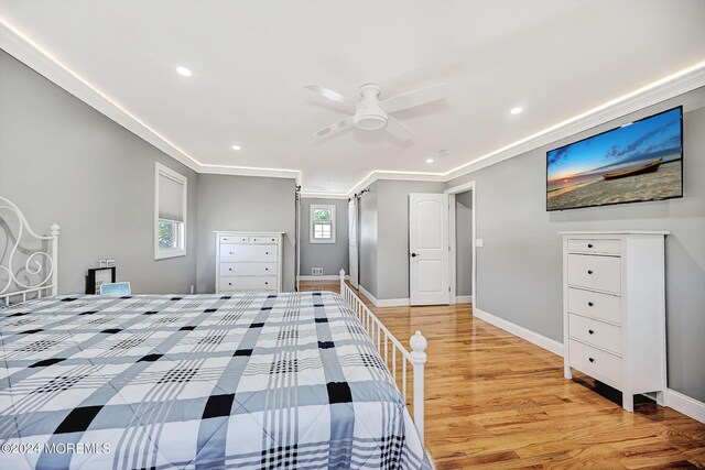 unfurnished bedroom featuring ornamental molding, light wood-type flooring, and ceiling fan