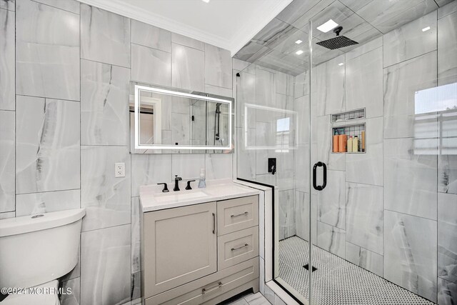 bathroom featuring tile walls, a shower with shower door, vanity, ornamental molding, and toilet