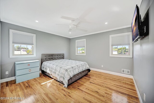 bedroom with light hardwood / wood-style floors, multiple windows, and ceiling fan