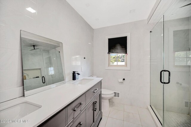 bathroom featuring tile walls, vanity, tile patterned flooring, toilet, and an enclosed shower