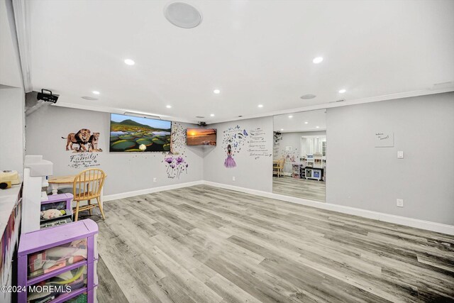 recreation room with light wood-type flooring and crown molding