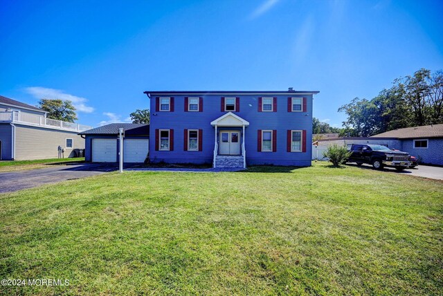 colonial home with a garage and a front yard