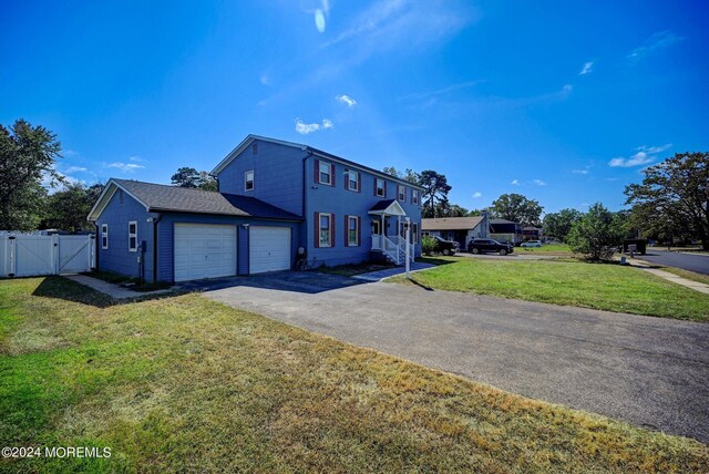 view of front of property featuring a front yard and a garage