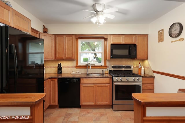 kitchen featuring dark stone countertops, tasteful backsplash, black appliances, ceiling fan, and sink