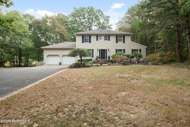 colonial house featuring a garage and a front yard