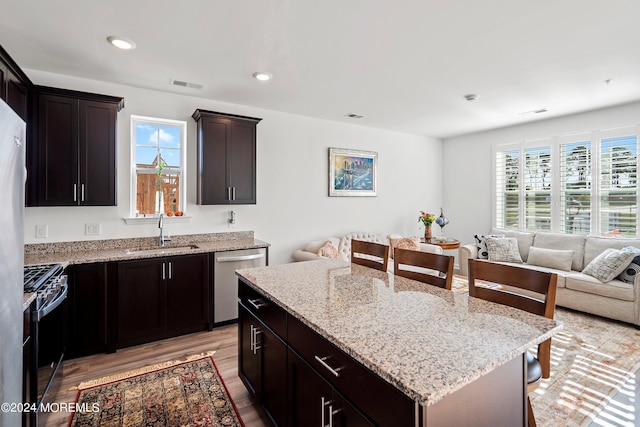 kitchen with a kitchen breakfast bar, a center island, sink, and stainless steel appliances