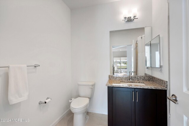 bathroom with tile patterned floors, vanity, and toilet