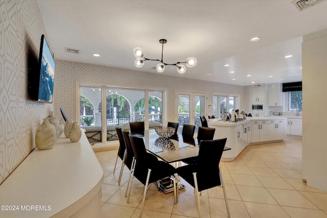 dining area featuring a notable chandelier, sink, and light tile patterned floors