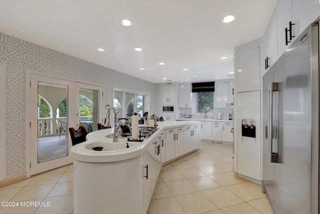 kitchen with white cabinetry, stainless steel appliances, a center island, french doors, and sink