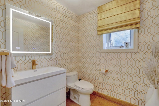 bathroom with tile patterned flooring, vanity, and toilet