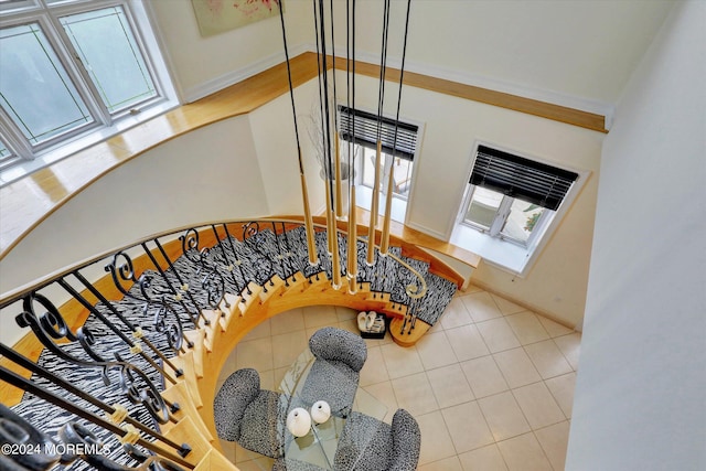 staircase with crown molding and tile patterned floors