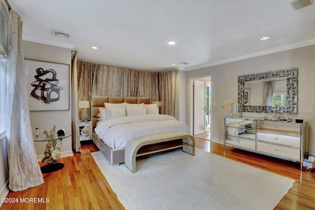 bedroom with ornamental molding and light wood-type flooring