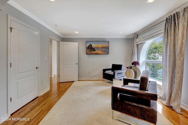 sitting room featuring crown molding and light hardwood / wood-style floors