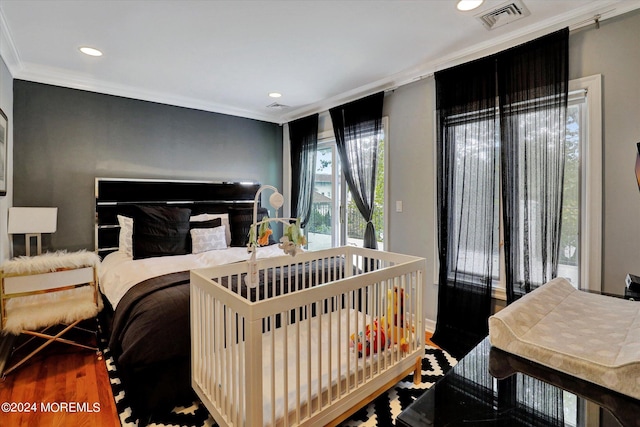 bedroom featuring ornamental molding and hardwood / wood-style flooring