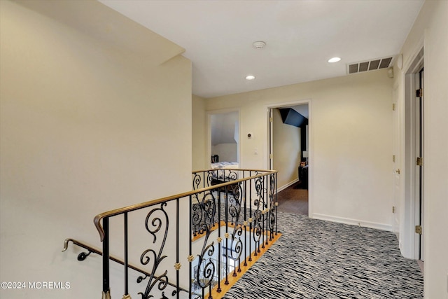 hallway with dark colored carpet