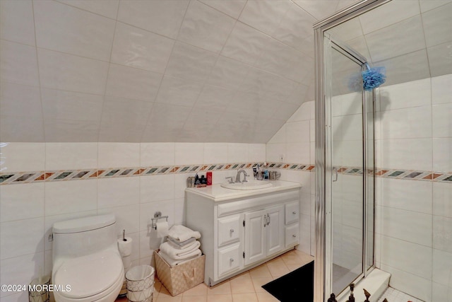 bathroom featuring tile walls, a shower with door, vanity, and toilet