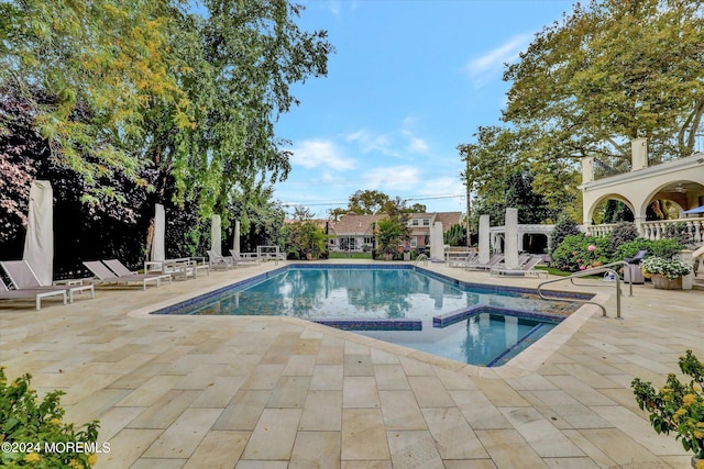 view of swimming pool featuring a patio and an in ground hot tub