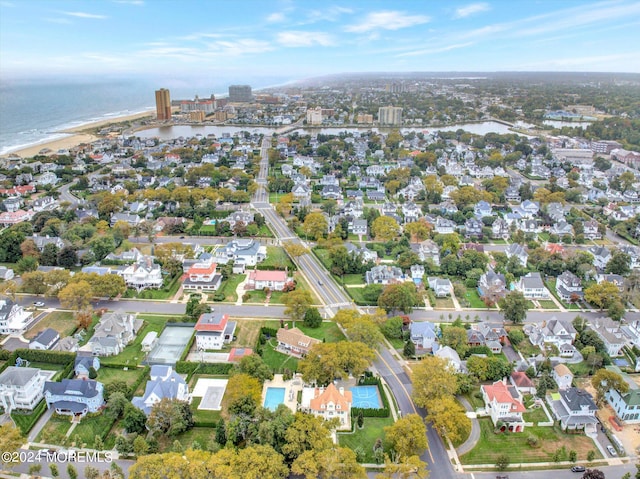 drone / aerial view with a water view and a beach view