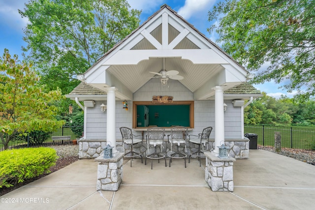 view of patio with exterior bar and ceiling fan