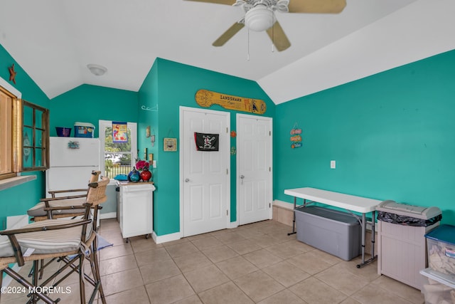 kitchen with ceiling fan, white refrigerator, lofted ceiling, and light tile patterned floors