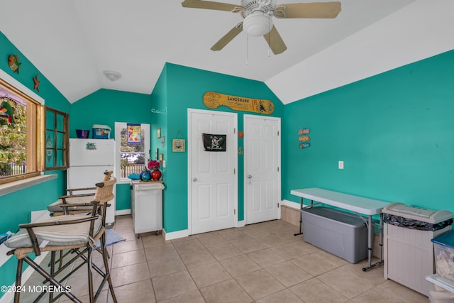 kitchen featuring ceiling fan, light tile patterned flooring, vaulted ceiling, and white fridge