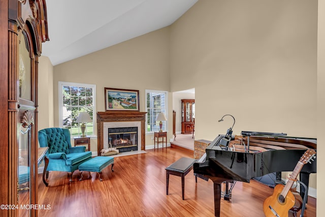 sitting room featuring hardwood / wood-style floors, a high end fireplace, and high vaulted ceiling