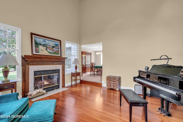 sitting room featuring a notable chandelier, hardwood / wood-style flooring, plenty of natural light, and a premium fireplace