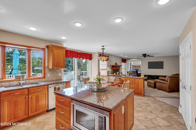 kitchen featuring ceiling fan, appliances with stainless steel finishes, plenty of natural light, and a center island