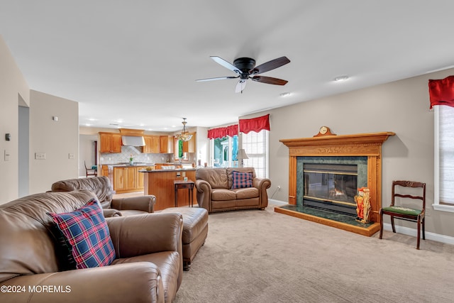 living room with a fireplace, ceiling fan, and light colored carpet