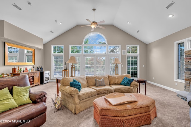 carpeted living room with ceiling fan, wine cooler, high vaulted ceiling, and indoor bar