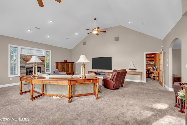 living room with high vaulted ceiling, ceiling fan, and a stone fireplace