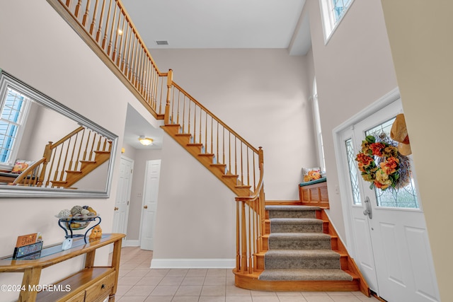 tiled entryway with a wealth of natural light and a high ceiling