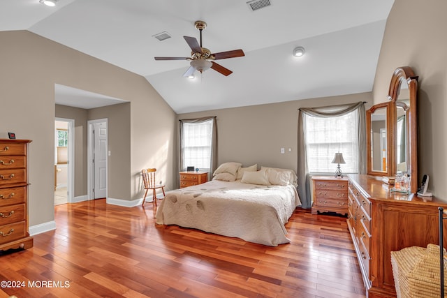 bedroom featuring vaulted ceiling, light hardwood / wood-style floors, and multiple windows