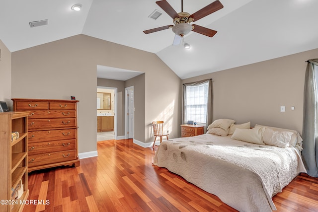 bedroom featuring ensuite bath, light hardwood / wood-style floors, vaulted ceiling, and ceiling fan