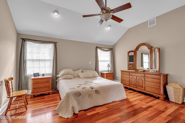 bedroom with ceiling fan, lofted ceiling, and light hardwood / wood-style flooring