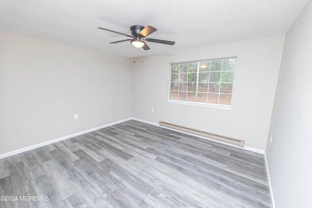 unfurnished room featuring a baseboard radiator, wood finished floors, a ceiling fan, and baseboards