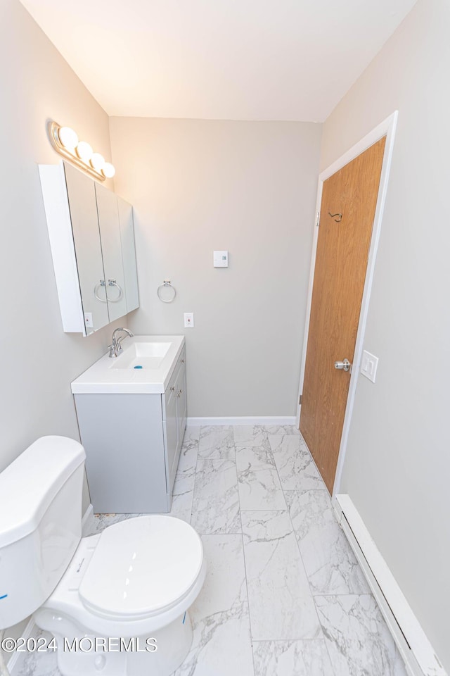 bathroom featuring toilet, marble finish floor, vanity, and baseboards