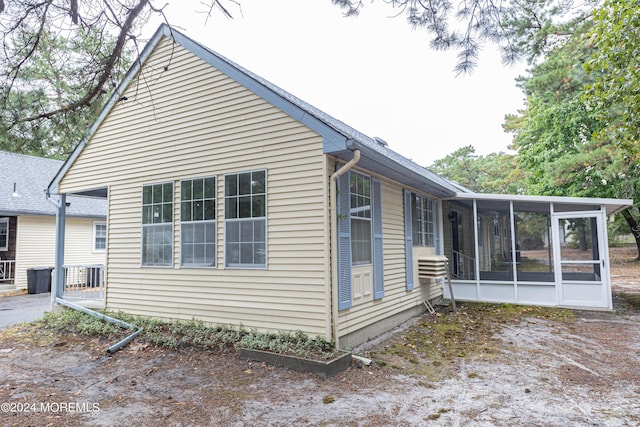 view of property exterior with a sunroom