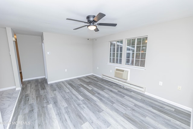 unfurnished room featuring baseboard heating, baseboards, wood finished floors, and a ceiling fan