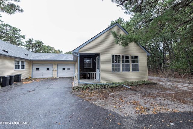 view of front of home with driveway, cooling unit, and an attached garage