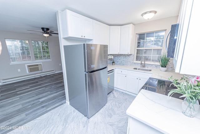 kitchen with a sink, baseboard heating, stainless steel appliances, and white cabinets