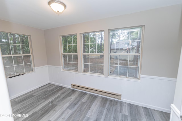 unfurnished room featuring baseboard heating and light hardwood / wood-style flooring