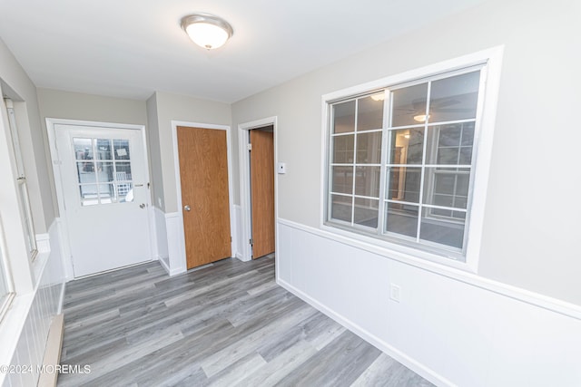 interior space with wood finished floors and a wainscoted wall