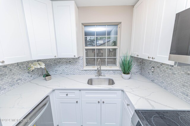 kitchen with white cabinetry, tasteful backsplash, appliances with stainless steel finishes, and a sink
