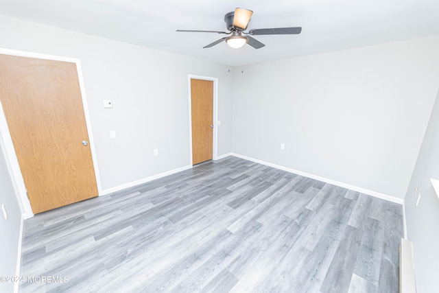 spare room with baseboards, a ceiling fan, and light wood-style floors