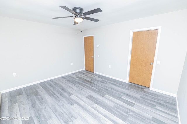 unfurnished room with light wood-style floors, a ceiling fan, and baseboards