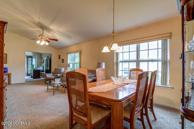 dining area featuring ceiling fan with notable chandelier, lofted ceiling, and carpet flooring