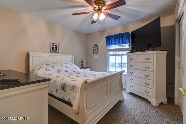 bedroom with dark colored carpet, ceiling fan, and a closet