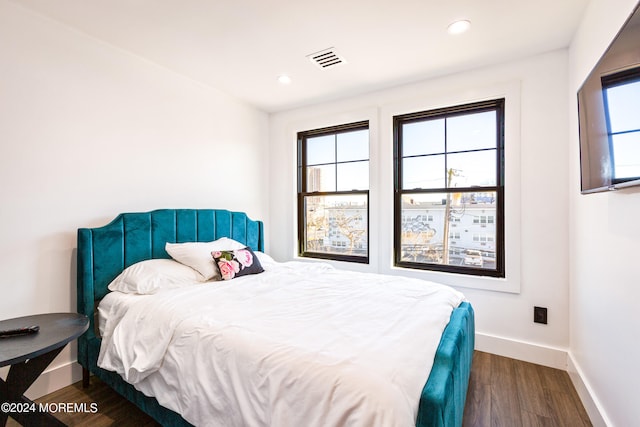 bedroom with dark hardwood / wood-style flooring